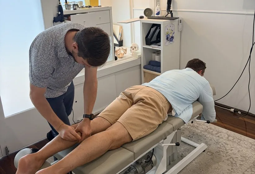 A practitioner treating a patient’s leg on the table